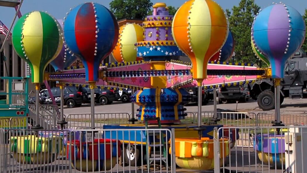 A carnival ride with balloons and a carousel.